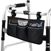 Black quilted walker bag attached to a folding walker, with three front pockets holding a phone, wallet, tissues, and other essentials.