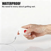 Water-resistant senior SOS call button held in a hand, showing the red emergency button, attached lanyard, and water droplets.
