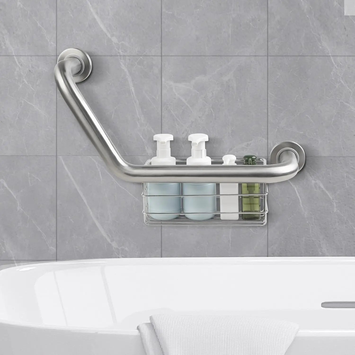 Silver angled grab bar mounted above a bathtub on gray tile, with the integrated wire basket holding shampoo and other toiletries.