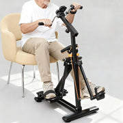 Seated senior using the arm and leg exerciser for simultaneous hand cycling and leg movement, with adjustable handles and foot straps visible.