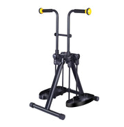 Black folding arm and leg exerciser with foam hand grips, yellow handle ends, foot pedals, and a wide floor base on a white background.