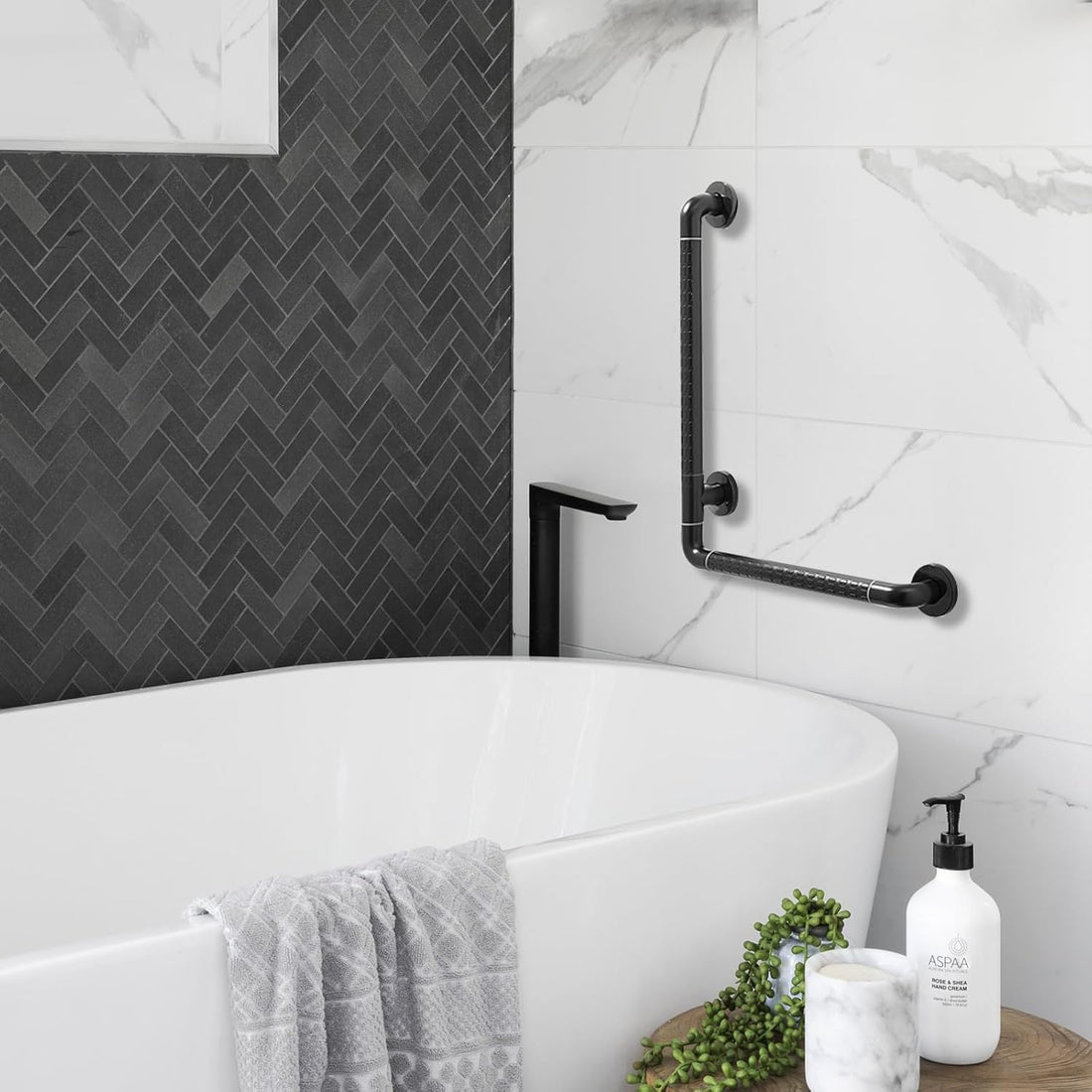 Black L-shaped bathroom grab bar installed on a tiled wall beside a bathtub, showing the vertical and horizontal support rails in a modern bathroom.
