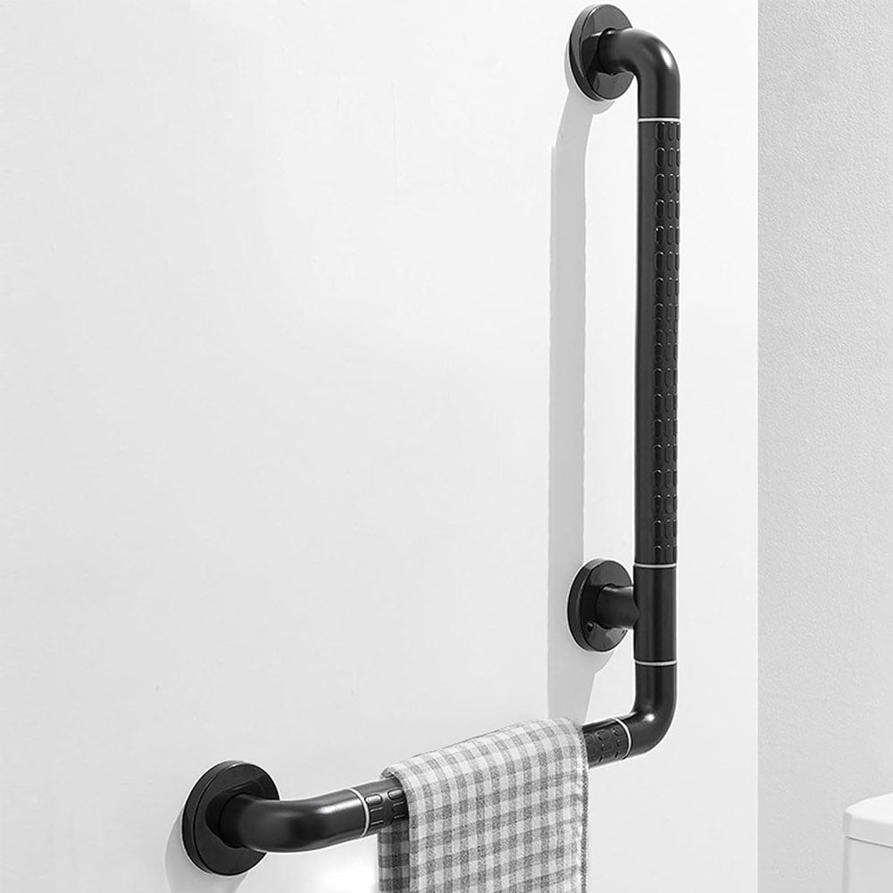 Black 16 x 24 inch L-shaped bathroom grab bar mounted on a wall, with textured grip sections, circular mounting plates, and a towel hanging from the horizontal rail.